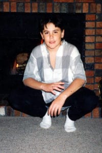 Tom Sandoval childhood photo in front of a fireplace